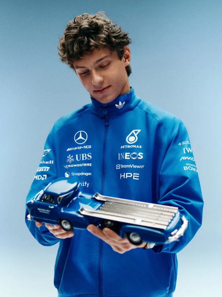 Qué es Blue Wonder, la colección de adidas y Mercedes F1 inspirada en un camión de 1955 Joven sosteniendo un modelo de coche.