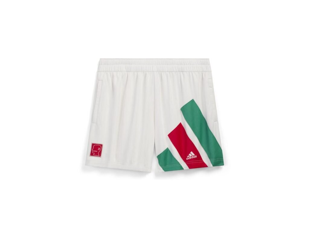 El calzado híbrido de adidas con Brain Dead que reimagina el fútbol de los 90 para la calle Imagen que muestra un pantalon blanco con una raya roja y dos verdes de la nueva colaboración de adidas con Brain Dead y Disney