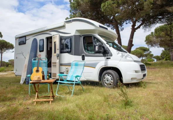 Imagen que muestra un autocaravana de alquiler aparcada en un paraje de Andalucía con zonas verdes.