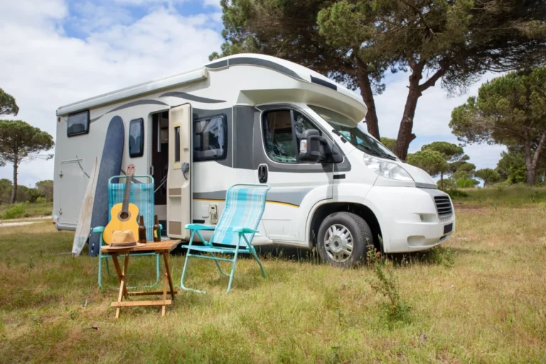 Imagen que muestra un autocaravana de alquiler aparcada en un paraje de Andalucía con zonas verdes.