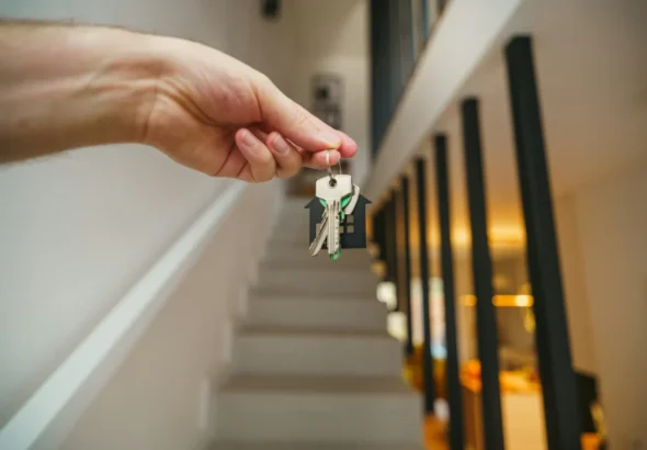 Imagen que muestra a una persona que sostiene las llaves de su casa de alquiler en Barcelona con las ayudas