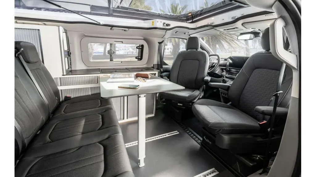 Ni hotel ni apartamento: la tendencia que arrasa para viajar por Andalucía este verano Imagen que muestra la autocaravana karman duncan 500. Asientos traseros con mesa de comedor.