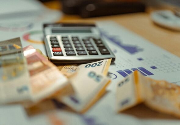 Imagen que muestra una calculada y documentos , además de billetes, para ilustrar el ahorro en la Renta 2025 de la Comunitat Valenciana con beneficios fiscales