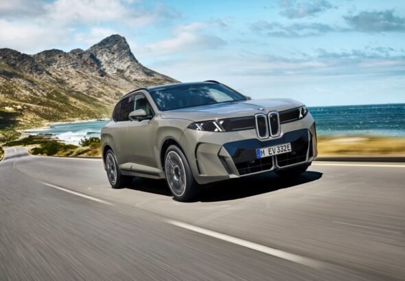 Imagen que muestra el nuevo BMW X5 circulando por una carretera con el mar de fondo mostrando el exterior frontal y lateral