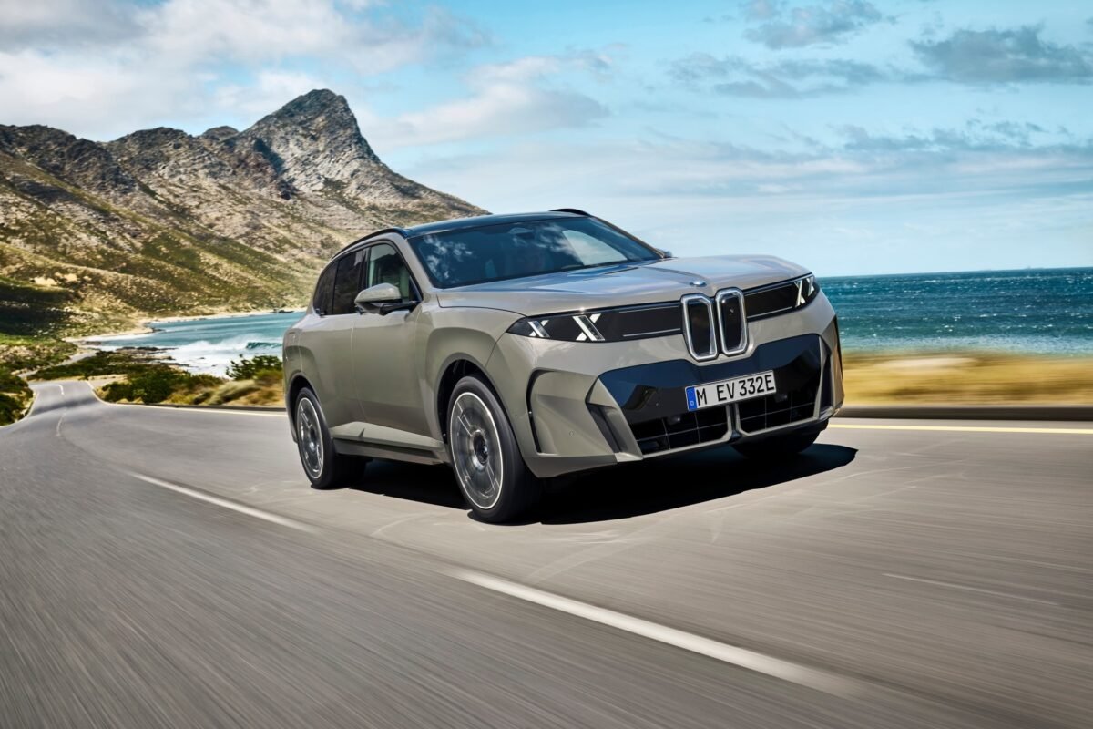 Imagen que muestra el nuevo BMW X5 circulando por una carretera con el mar de fondo mostrando el exterior frontal y lateral