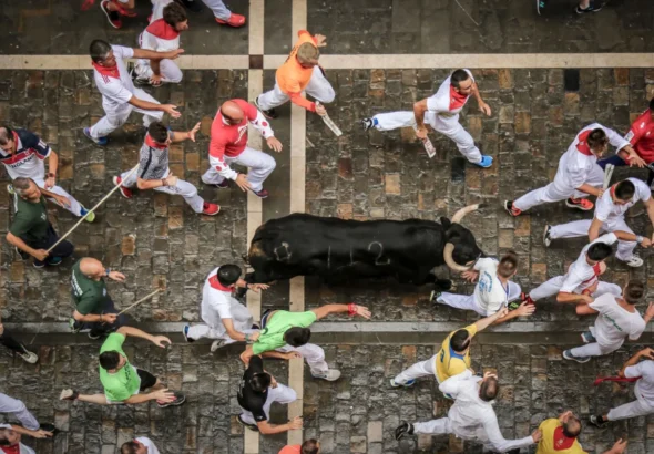 El Encierro de San Fermín que muestra una vista aérea de los corredores con el toro