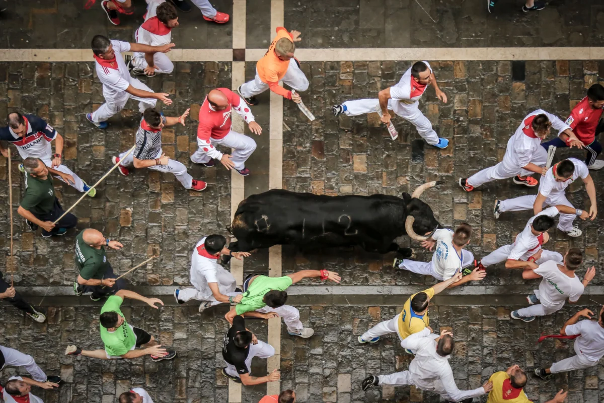 El Encierro de San Fermín que muestra una vista aérea de los corredores con el toro
