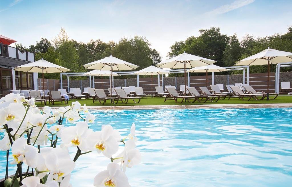 La escapada a la campiña alemana para volver a conectar con la calma del bosque Imagen del la piscina exterior del Land & Golf Hotel Stromberg