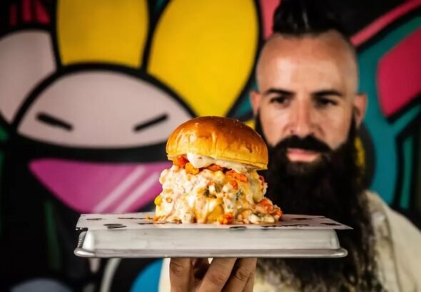 Moflete, el restaurante de Joe Burger Challenge , tiene un descuento hasta final de septiembre en sus menús para 2 y 4 personas. En la imagen muestra a Joe Burger con una hamburguesa de Moflete en la mano.