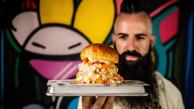 Moflete, el restaurante de Joe Burger Challenge , tiene un descuento hasta final de septiembre en sus menús para 2 y 4 personas. En la imagen muestra a Joe Burger con una hamburguesa de Moflete en la mano.