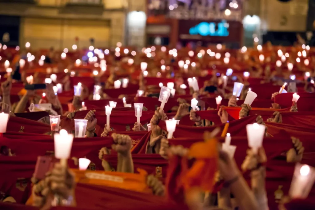 Sanfermines al descubierto: Viaja al corazón de la fiesta más salvaje y legendaria con su historia San Fermín muestra las velas y los pañuelos rojos al aire en Ay pobre de mí que da fin a las fiestas