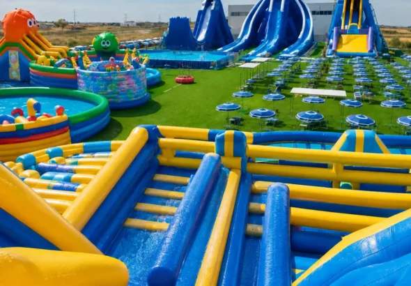 El parque WOW Bonaire en Valencia abre todo el verano con atracciones de agua como muestra la imagen con cesped y sombrillas