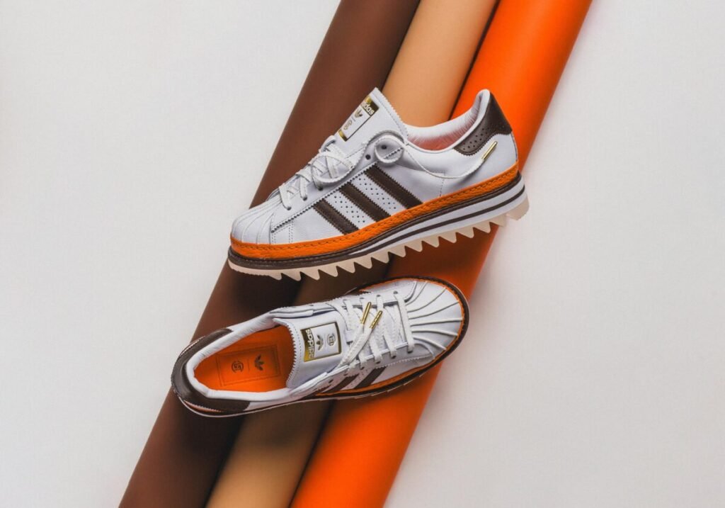 Adiós a aburrirte con las zapatillas blancas de siempre Las CLOT Superstar by Edison Chen en una imagen de catálogo con el par completo vista una de lateral y la otra cenital.