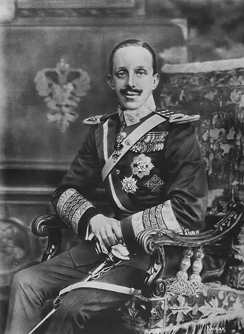 Retrato de cuerpo entero del rey Alfonso XIII sentado.