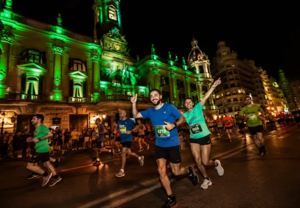 15K Nocturna Valencia, corredores atravesando la plaza del Ayuntamiento durante una carrera nocturna